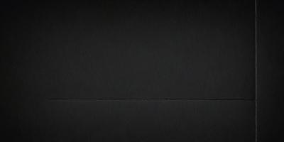 The primary subject of the image is a black background. The setting is a dark room, and the visual style is a black and white photo. The colors and mood of the image are predominantly dark and moody.