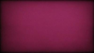 The primary subject of the image is a large, pink surface. The setting is a dark room, and the visual style appears to be a photo. The dominant colors are pink and purple, creating a warm and inviting atmosphere.