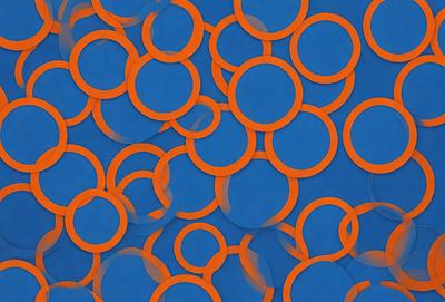 The primary subject of the image is a pattern of orange and blue circles. The setting is a blue background, and the visual style appears to be a digital art or illustration. The dominant colors are orange and blue, creating a vibrant and lively atmosphere.
