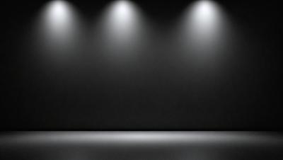 The primary subject of the image is a black background with a light source, creating a dramatic and moody atmosphere. The setting is a dark room with a light source, possibly a stage or a studio. The visual style is a black and white photo, which adds to the dramatic and artistic feel of the image. The colors and mood are predominantly dark and intense, with the light source serving as a focal point in the scene.