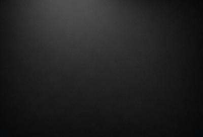 The primary subject of the image is a black background with a white dot. The setting is a dark room, and the visual style is a simple, monochromatic design. The colors and mood of the image are predominantly dark and moody, with the white dot being the only bright spot in the scene.