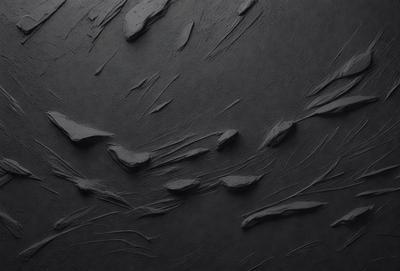 The primary subject of the image is a black surface with a pattern of white lines. The setting appears to be a dark room, and the visual style is a combination of a photo and a drawing. The dominant colors are black and white, creating a moody atmosphere.