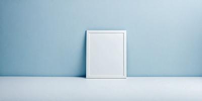 The primary subject of the image is a white picture frame. The setting is a blue wall, which serves as the backdrop for the picture frame. The visual style is a photo, capturing the white frame against the blue wall. The colors and mood of the image are predominantly blue, creating a calm and serene atmosphere.