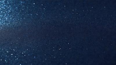 The primary subject of the image is a dark blue sky filled with stars. The setting is a nighttime sky, and the visual style is a photo. The colors and mood of the image are predominantly dark and moody, with the blue sky and the twinkling stars creating a sense of depth and mystery.