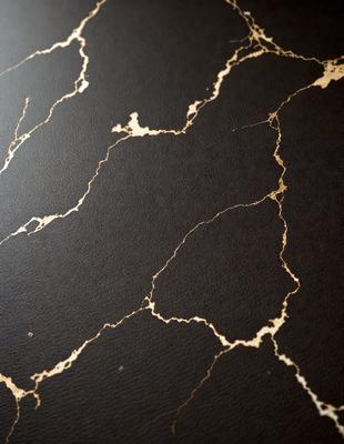 The primary subject of the image is a black and gold leather surface. The setting is a black background, and the visual style appears to be a combination of a photo and digital art. The colors and mood of the image are predominantly black and gold, creating a luxurious and elegant atmosphere.