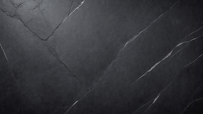 The primary subject of the image is a black marble countertop. The setting is a dark room, and the visual style is a close-up of the marble countertop. The countertop appears to be cracked, giving it a unique and aged appearance. The colors and mood of the image are dark and moody, with the black marble countertop being the main focal point.