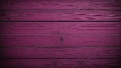 The primary subject of the image is a wooden wall with a purple color. The setting is a room with a wooden floor. The visual style is a close-up of the wooden wall, showcasing its texture and color. The dominant colors are purple and brown, creating a warm and cozy atmosphere.