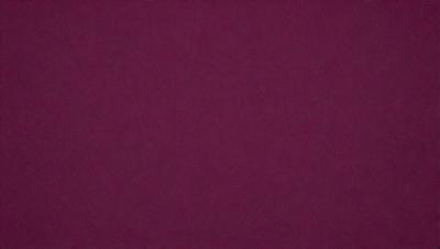 The primary subject of the image is a close-up of a maroon or burgundy fabric. The setting is a dark background, which contrasts with the fabric. The visual style is a close-up, focusing on the fabric's texture and color. The colors and mood of the image are predominantly dark and moody, with the maroon fabric serving as the main focal point.