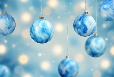The primary subject of the image is a group of blue and white Christmas ornaments hanging from strings. The ornaments are suspended in the air, creating a festive and holiday atmosphere. The setting is a blue background, which complements the colors of the ornaments. The visual style is a combination of photo and digital art, as the ornaments are captured in a realistic manner while the blue background adds a touch of digital artistry. The colors and mood of the image are predominantly blue and white, evoking