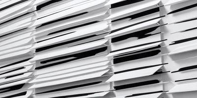 The primary subject of the image is a stack of white envelopes. The setting is a black and white background, which gives the image a classic and timeless appearance. The visual style is a close-up of the envelopes, showcasing their texture and details. The colors and mood of the image are predominantly black and white, creating a sense of elegance and simplicity.
