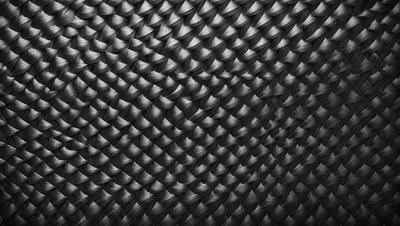 The primary subject of the image is a black and white pattern, which appears to be a woven or knitted fabric. The setting is a black background, which contrasts with the pattern. The visual style is a close-up of the pattern, showcasing its intricate details. The colors and mood of the image are predominantly black and white, giving it a classic and timeless appearance.