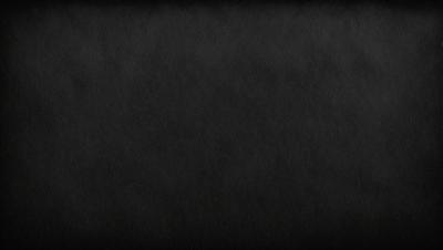 The primary subject of the image is a black background. The setting is a dark room, and the visual style is a black and white photo. The colors and mood of the image are dark and moody, creating a dramatic atmosphere.