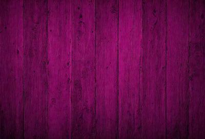 The primary subject of the image is a purple wooden wall. The setting is a room with a purple wooden floor. The visual style is a close-up of the wooden wall, which gives a sense of texture and depth. The colors and mood of the image are predominantly purple, creating a calm and serene atmosphere.
