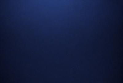 The primary subject of the image is a large, dark blue sky. The setting is a vast, open space with no visible landmarks or objects. The visual style is a natural, untouched environment. The colors and mood are predominantly dark and moody, with the blue sky serving as the main focal point.