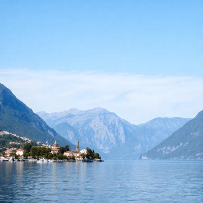 Primary subject: A beautiful mountain lake with a small island in the middle.

Setting/background: The background features a mountain range, adding to the picturesque scenery.

Visual style: The image is a photo, capturing the natural beauty of the landscape.

Colors and mood: The scene is dominated by shades of blue and green, reflecting the calm and serene atmosphere of the lake and mountains.