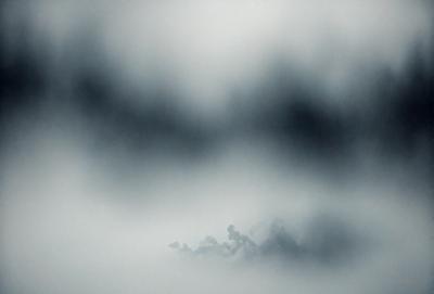 The primary subject of the image is a cloudy sky. The setting is a cloudy day with a gray sky, and the visual style is a photo. The colors and mood of the image are predominantly dark and moody, with the clouds creating a dramatic atmosphere.