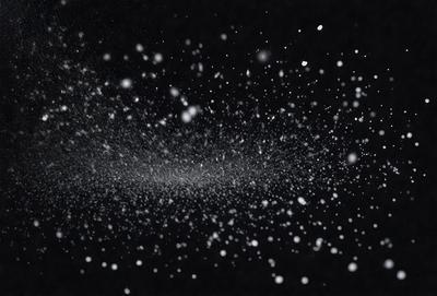 The primary subject of the image is a snowy scene with a black background. The setting appears to be a nighttime environment, possibly in a snowy forest. The visual style of the image is a photo, capturing the beauty of the snowfall. The dominant colors in the image are black and white, creating a dramatic and serene atmosphere.