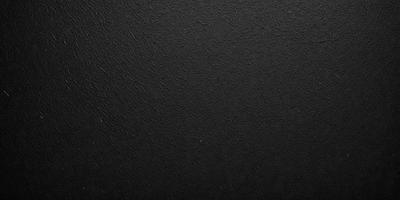 The primary subject of the image is a black background. The setting is a black surface, which creates a stark contrast with the background. The visual style is a black and white photo, giving the image a classic and timeless appearance. The colors and mood are predominantly dark and moody, with the black background and the lack of color creating a sense of depth and intensity.