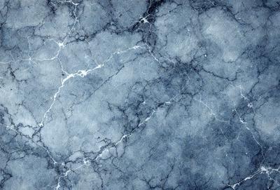The primary subject of the image is a blue marble wall with a pattern of white veins. The setting is a room with a blue marble floor. The visual style is a close-up of the marble wall, showcasing its unique texture and pattern. The colors and mood of the image are predominantly blue, creating a calm and serene atmosphere.