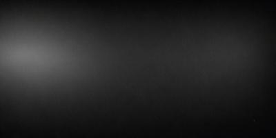 The image is a black and white photo of a dark background. The primary subject is a large, empty space with no visible objects or details. The setting is a black background, which creates a stark contrast with the subject. The visual style is a black and white photo, giving the image a classic and timeless appearance. The colors and mood are predominantly dark and moody, with the black background emphasizing the emptiness of the space.