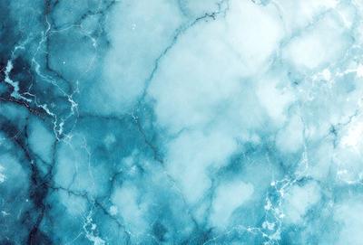 The primary subject of the image is a blue marble wall with a white and blue pattern. The setting is a room with a blue marble wall, and the visual style is a painting. The dominant colors are blue and white, creating a calm and serene atmosphere.