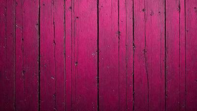 The primary subject of the image is a wooden wall with a pinkish hue. The setting is a room with a wooden surface, and the visual style appears to be a photo. The dominant colors in the image are pink and brown, creating a warm and inviting atmosphere.