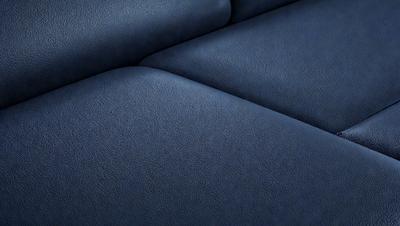 The primary subject of the image is a blue leather couch. The setting is a room with a blue background. The visual style is a photo of the couch. The colors and mood are predominantly blue, creating a calm and relaxing atmosphere.