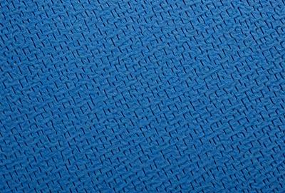 The primary subject of the image is a blue fabric with a pattern of interlocking diamond shapes. The setting is a close-up of the fabric, showcasing the intricate design. The visual style is a detailed, textured representation of the fabric. The colors and mood are predominantly blue, creating a calm and soothing atmosphere.