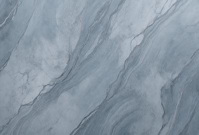 The primary subject of the image is a marble-like surface with a pattern of swirls and waves. The setting is a gray stone wall, which serves as the background. The visual style is a close-up of the marble pattern, showcasing the intricate details of the swirls and waves. The colors and mood of the image are predominantly gray, giving it a calm and sophisticated atmosphere.