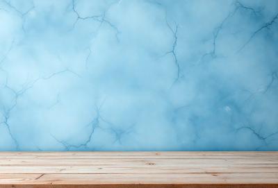 The primary subject of the image is a wooden table with a blue marble-like surface. The setting is a room with a blue wall, and the visual style appears to be a photo. The dominant colors are blue and white, creating a calm and serene atmosphere.