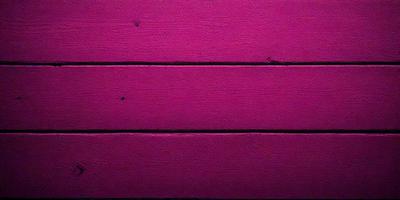 The primary subject of the image is a pink wooden wall. The setting is a room with a pink wooden wall, and the visual style is a photo. The dominant colors in the image are pink, and the overall atmosphere is warm and inviting.