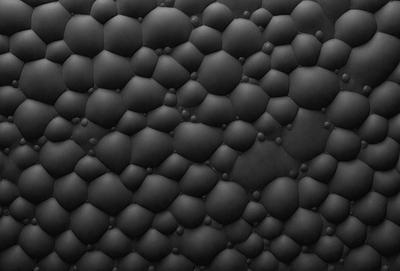 The primary subject of the image is a black background with a pattern of small, round, black circles. The setting is a dark room, and the visual style appears to be a close-up of the black background with the circles. The overall atmosphere is dark and moody, with the black circles creating a sense of depth and texture.