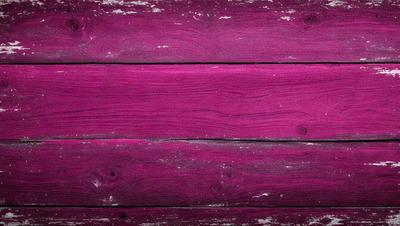 The primary subject of the image is a wooden plank with a purple color. The setting is a wooden wall, and the visual style is a close-up of the wooden plank. The colors and mood of the image are predominantly purple, creating a unique and striking appearance.