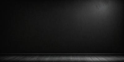 The primary subject of the image is a black wall with a wooden floor. The setting is a room with a wooden floor, and the visual style is a black and white photo. The dominant colors are black and white, creating a stark and minimalist atmosphere.