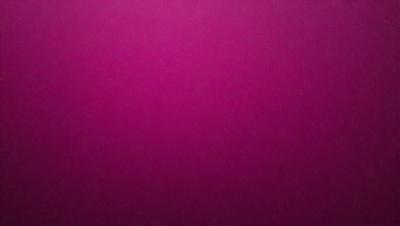 The primary subject of the image is a large, purple wall. The setting is a room with a pink background, which creates a contrasting and vibrant atmosphere. The visual style is a close-up of the wall, showcasing its color and texture. The dominant colors are purple and pink, giving the scene a warm and inviting mood.