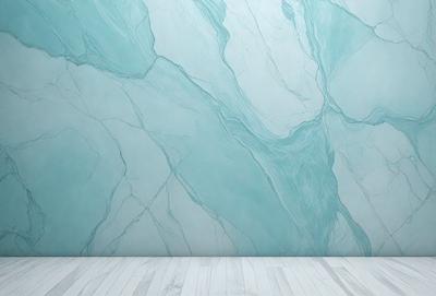 The primary subject of the image is a wall with a marble-like texture. The setting is a white room with a blue wall, which adds a contrasting color to the scene. The visual style is a close-up of the wall, showcasing the intricate design of the marble-like texture. The colors and mood of the image are predominantly blue and white, creating a clean and elegant atmosphere.