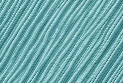 The primary subject of the image is a blue, wavy, and textured surface. The setting is a blue background, and the visual style is a close-up of the blue surface. The colors and mood of the image are predominantly blue, creating a calm and serene atmosphere.