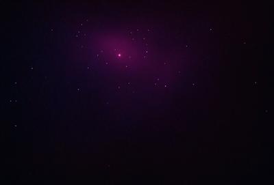 The primary subject of the image is a purple starry background. The setting is a dark, purple sky, which creates a dramatic and moody atmosphere. The visual style is a combination of a photo and digital art, as the purple starry background appears to be a digital creation, while the overall image is a photograph. The colors and mood of the image are predominantly purple, with the starry background adding a sense of wonder and mystery to the scene.