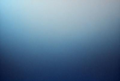 The primary subject of the image is a large, open, and empty blue sky. The setting is a vast, cloudless expanse, with no visible landmarks or objects. The visual style is a natural, untouched landscape, with no indication of digital manipulation or artistic elements. The colors and mood are predominantly blue, conveying a sense of tranquility and vastness.