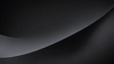 The primary subject of the image is a large, curved surface that appears to be a black wall or a black background. The setting is a dark room, and the visual style is a black and white photo. The dominant colors are black and white, creating a moody and dramatic atmosphere.