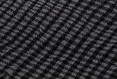 The primary subject of the image is a black and white checkered pattern. The setting is a black background, and the visual style is a pattern. The dominant colors are black and white, creating a classic and timeless atmosphere.