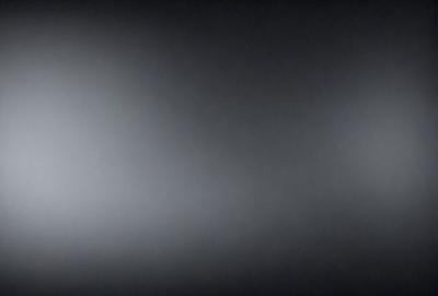 The image is a black and white photo of a dark room. The primary subject is a large, empty space with no visible objects or people. The setting is a dark room, and the visual style is a black and white photo. The colors and mood are dark and moody, creating a sense of mystery and solitude.