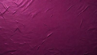 The primary subject of the image is a purple fabric with a wrinkled texture. The setting is a close-up of the fabric, showcasing its unique pattern and texture. The visual style is a realistic representation of the fabric, capturing its natural appearance. The colors and mood of the image are predominantly purple, creating a calm and soothing atmosphere.