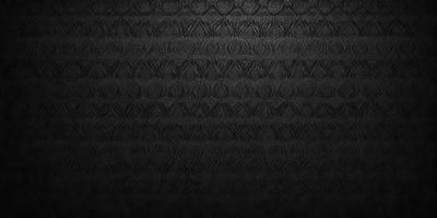 The primary subject of the image is a patterned wallpaper with a black background. The setting is a room with a black wall, and the visual style is a close-up of the wallpaper. The colors and mood of the image are predominantly black, giving it a dark and moody atmosphere.