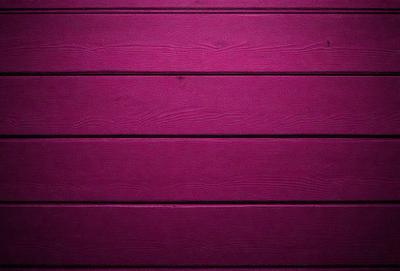 The primary subject of the image is a purple wall. The setting is a wooden wall, and the visual style is a photo. The dominant colors are purple and pink, creating a warm and inviting atmosphere.