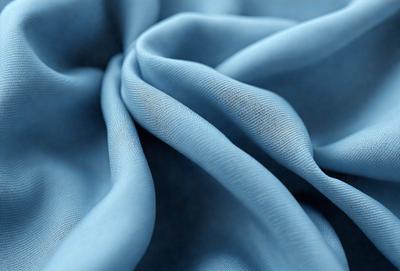 The primary subject of the image is a blue fabric, possibly a piece of cloth or a curtain. The setting is a room with a blue background, which creates a cohesive and visually appealing environment. The visual style of the image is a close-up of the blue fabric, showcasing its texture and details. The colors and mood of the image are predominantly blue, giving it a calm and serene atmosphere.