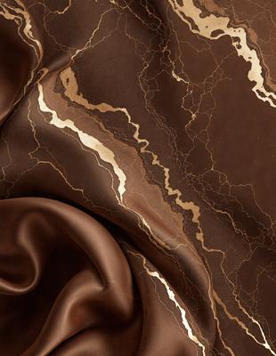 The primary subject of the image is a brown fabric with gold and brown patterns. The setting is a close-up of the fabric, showcasing its intricate design. The visual style is a detailed, textured photograph of the fabric. The colors and mood of the image are warm and earthy, with the gold and brown tones creating a sense of richness and sophistication.