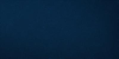 The primary subject of the image is a large, dark blue surface. The setting is a vast, open space with no visible objects or people. The visual style is a simple, monochromatic design. The dominant colors are shades of blue, creating a calm and serene atmosphere.
