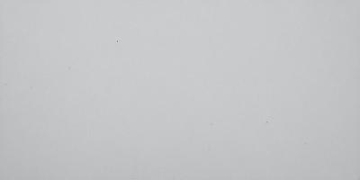 The image is a white background with a single black dot in the center. The dot is the primary subject, and it appears to be the focal point of the image. The setting is a blank white surface, which creates a clean and minimalist visual style. The colors are predominantly white and black, giving the image a simple and monochromatic appearance.