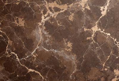 The primary subject of the image is a marble wall with a brown and gold color scheme. The setting is a room with a brown and gold marble wall as the main focus. The visual style is a close-up of the marble wall, showcasing its intricate patterns and textures. The colors and mood of the image are warm and earthy, with the brown and gold tones creating a sense of luxury and sophistication.